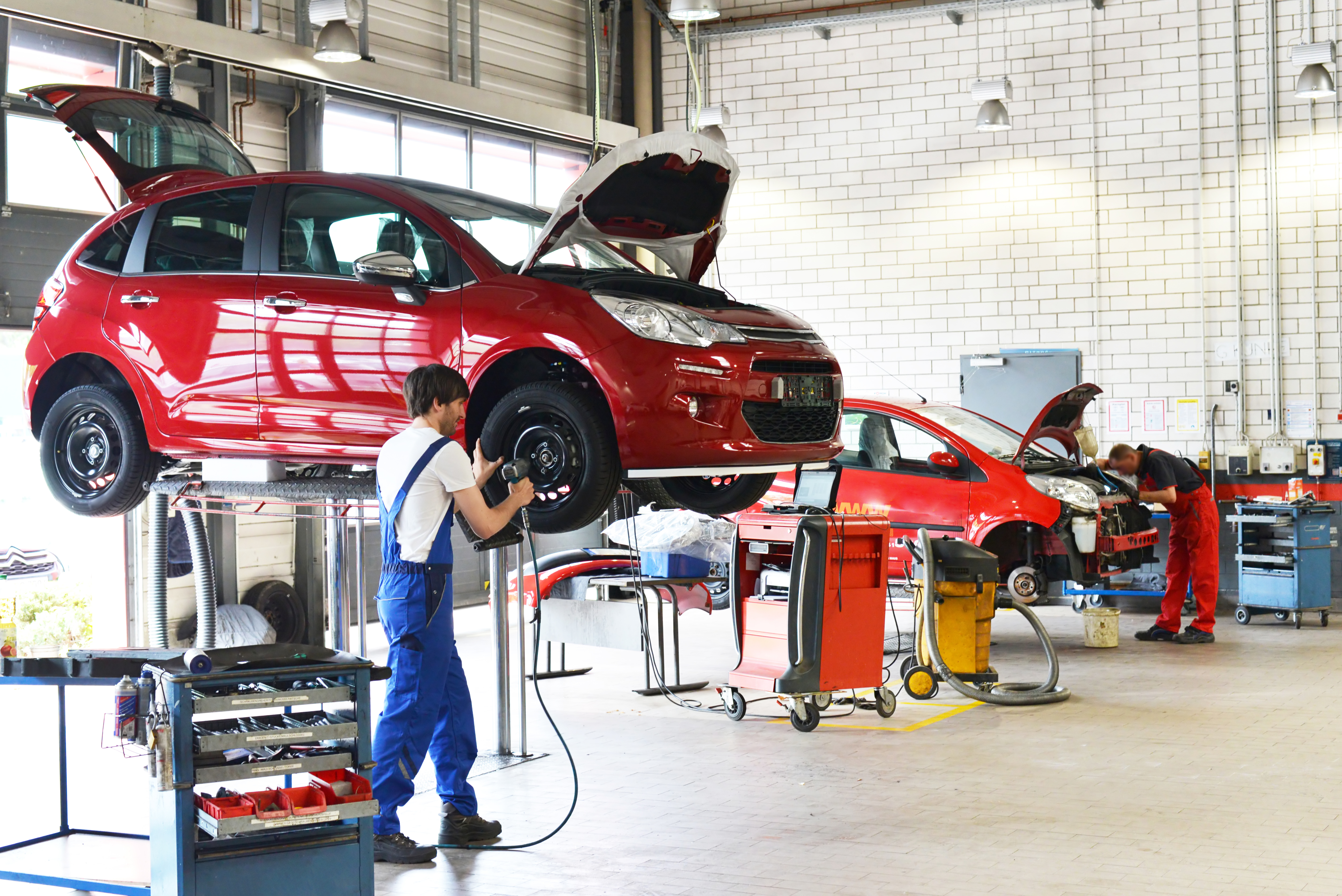 Red car on workshop lift at BK MOT Centre